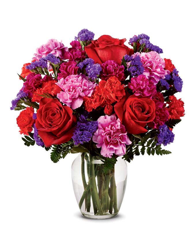 Red rose and hot pink carnations in clear glass vase
