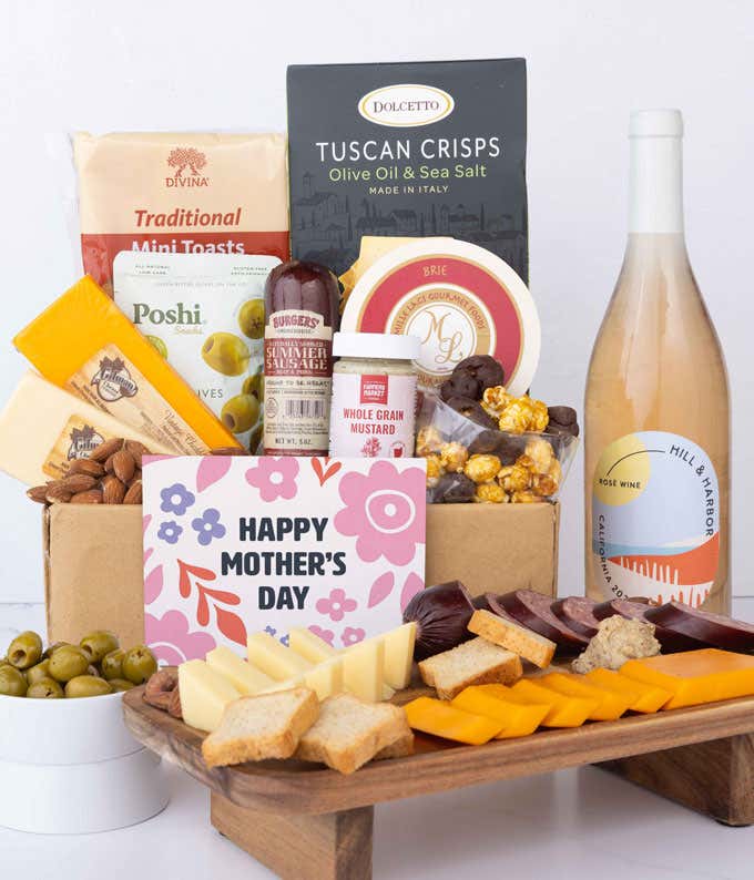 A charcuterie spread with 3 cheeses, summer sausage, olives, crackers, mustard, almonds, and chocolate treats finished with a bottle of Rosé wine and 'Happy Mother's Day' card.