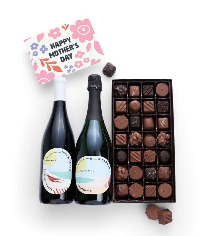 Bottles of Hill & Harbor Pinot Noir and Sparkling wine sit alongside a 1 lb. box of assorted chocolates and a 'Happy Mother's Day' card.