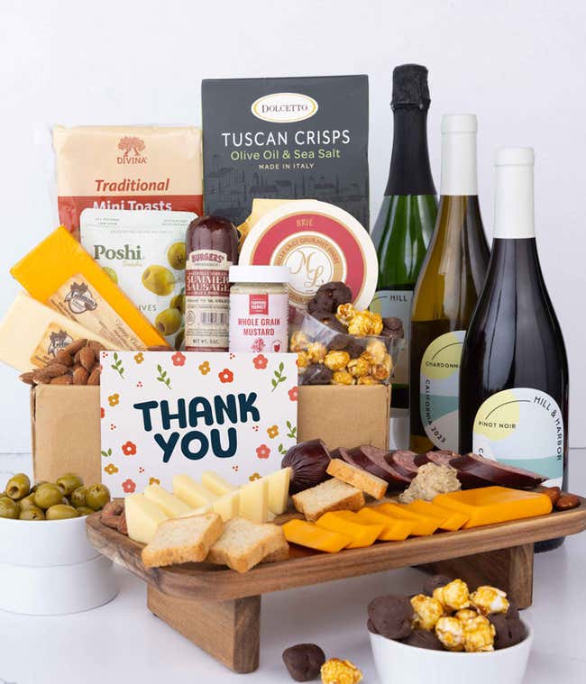 A wine and cheese gift set featuring bottles of Hill &amp; Harbor sparkling wine, Chardonnay, and Pinot Noir. Includes a variety of gourmet cheeses, crackers, olives, summer sausage, almonds, salami, and condiments finished with a Thank You card.