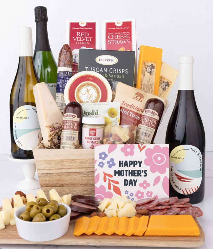 Grand Mother’s Day charcuterie crate with Hill & Harbor Chardonnay, Pinot Noir, Sparkling Wine, artisan salami and sausage, cheeses, olives, crisps, cookies, and floral card, displayed with sliced meats and cheeses.